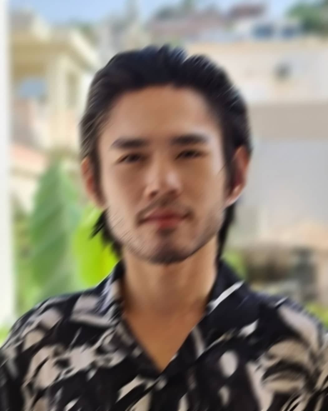 blurry headshot of a worldwide handsome bearded Asian man