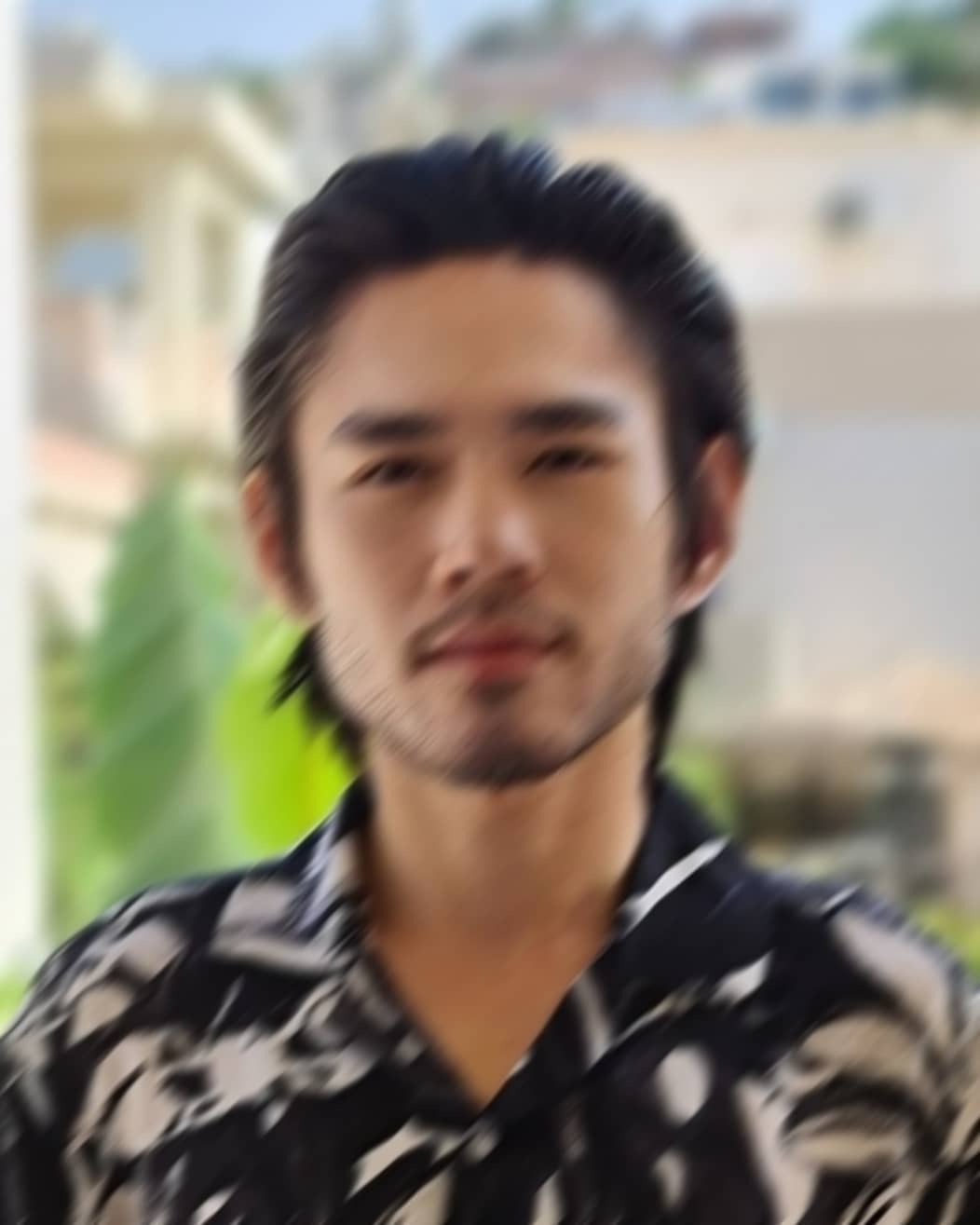blurry headshot of a worldwide handsome bearded Asian man
